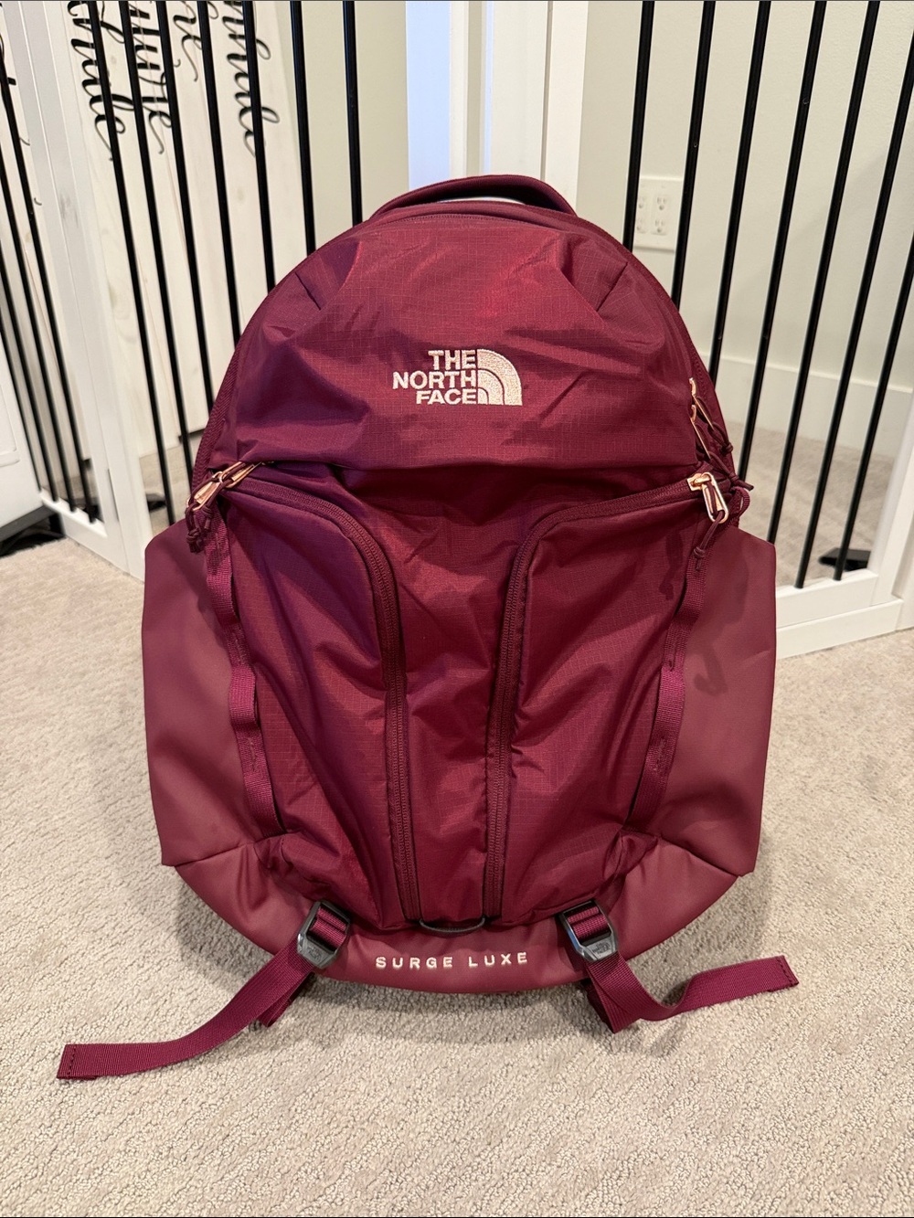 The North Face Surge Luxe Backpack in Burgundy Red and rose gold hardware.
